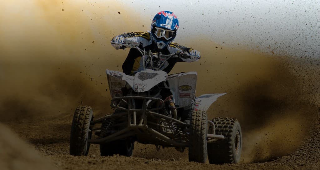 ATV rider kicking up dust on a dirt track